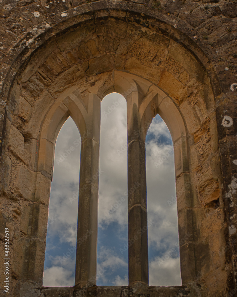 arches of the castle window with blue sky and clouds
