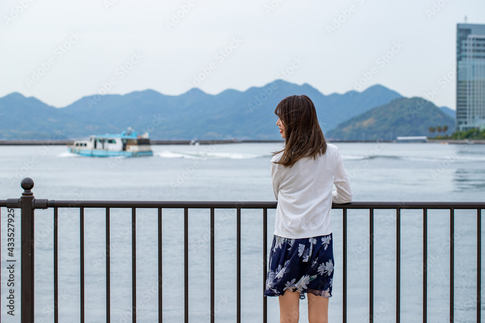 海を眺める女性の後ろ姿