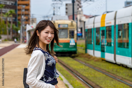 電車を待つ笑顔の女性