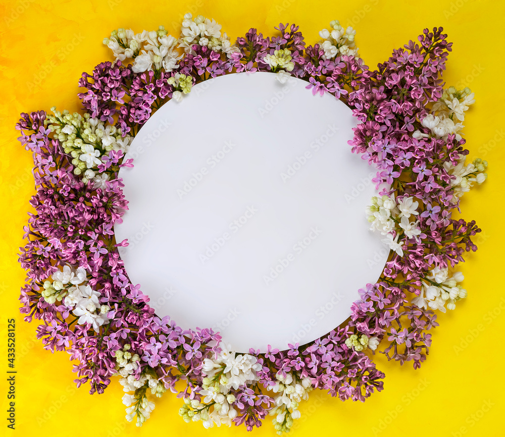 White frame with lilac flowers on yellow background White frame with lilac flowers on yellow background