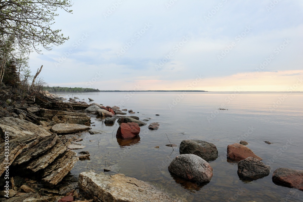 Beautiful sunset on a calm lake with a rocky shore