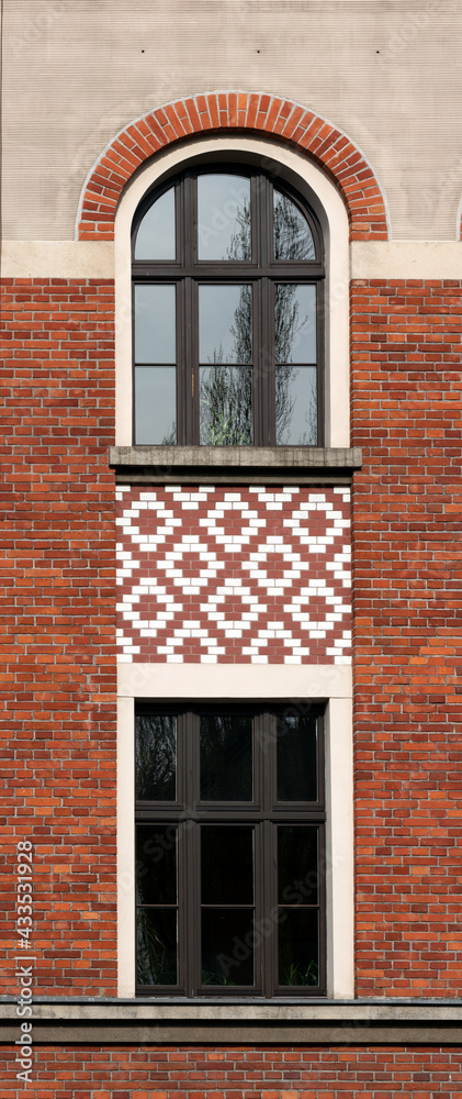 Tekstura elewacji budynku z dwoma oknami. Ściana z cegły czerwonej i białej