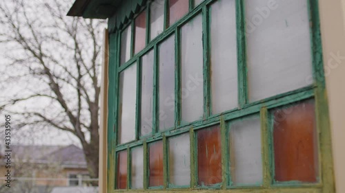 An old wooden window with multicolored panes. Multicolored glass panels on the antique window.