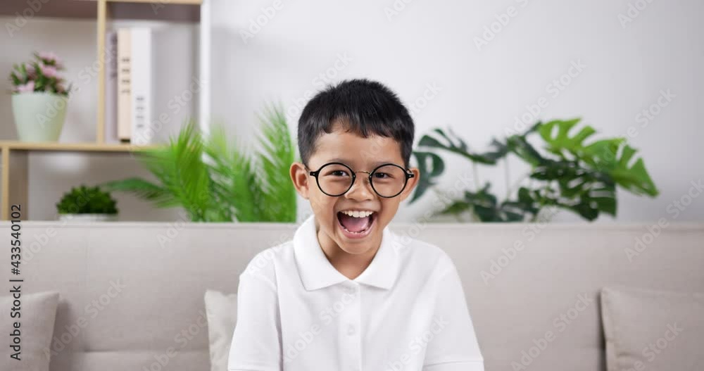 Asian boy wearing glasses very happy.