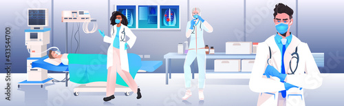 doctors in masks and protective suits preparing coronavirus vaccine injection for woman patient fight against covid-19