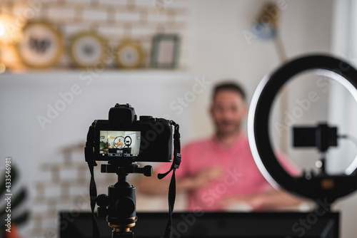 detrás de cámara de un hombre siendo entrevistado con luces y micrófonos para un blog photo