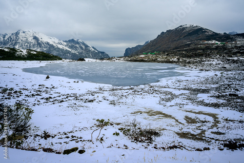 Scenic lake in snow-covered mountains in winter. Tisri udasi Lake, where Gurudwara Sahib situated, Tawang, Arunachal Pradesh, India. photo