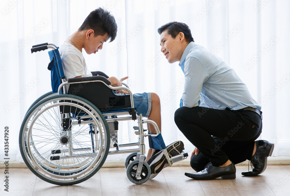 Asian doctor talking, support, and encouragement to a young disabled boy in a wheelchair Asian doctor talking, support, and encouragement to a young disabled boy in a wheelchair
