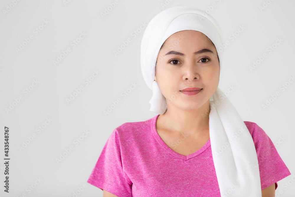 Portrait of a woman cancer patient with clothes covered around head affected from chemotherapy cure process posing with positive and self-confidence Portrait of a woman cancer patient with clothes covered around head affected from chemotherapy cure process posing with positive and self-confidence