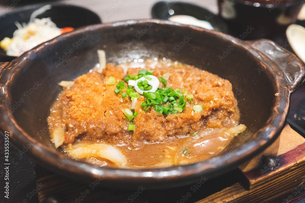 Crispy fried pork or Tonkatsu with miso sauce in the bowl. Japanese food.