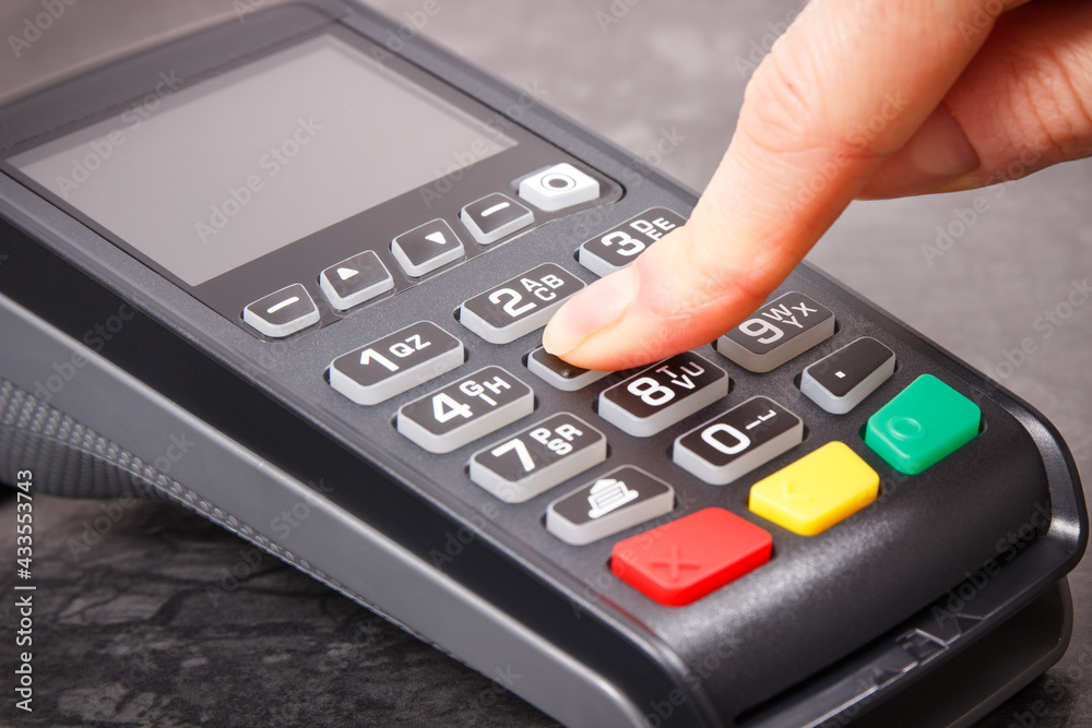 Hand of woman using credit card reader to enter PIN code. Cashless paying. Finance and banking Hand of woman using credit card reader to enter PIN code. Cashless paying. Finance and banking