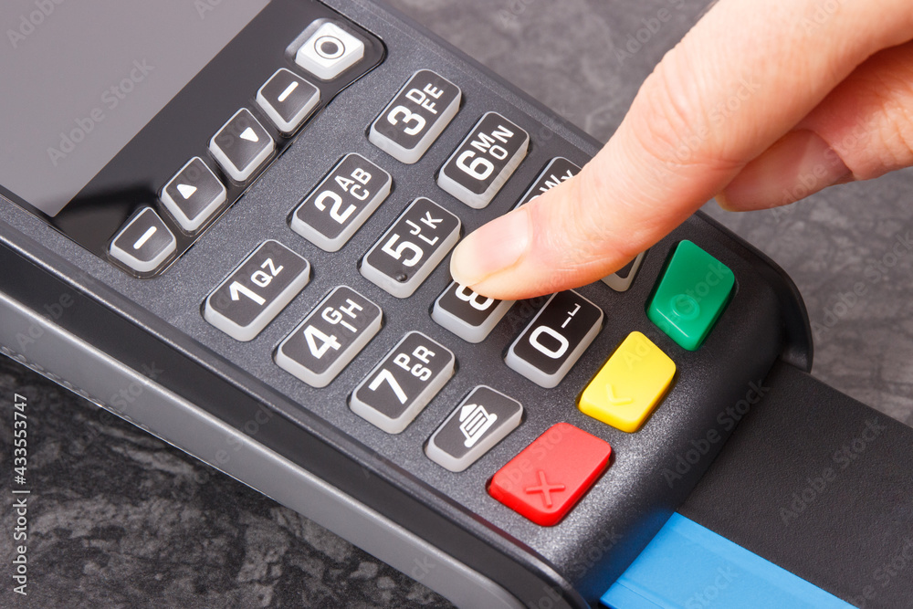 Hand of woman entering PIN code on payment terminal. Cashless paying for shopping. Finance concept Hand of woman entering PIN code on payment terminal. Cashless paying for shopping. Finance concept