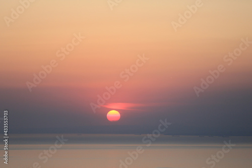 sunset view. Cloudy sky, sea and red sun © bahadirbermekphoto