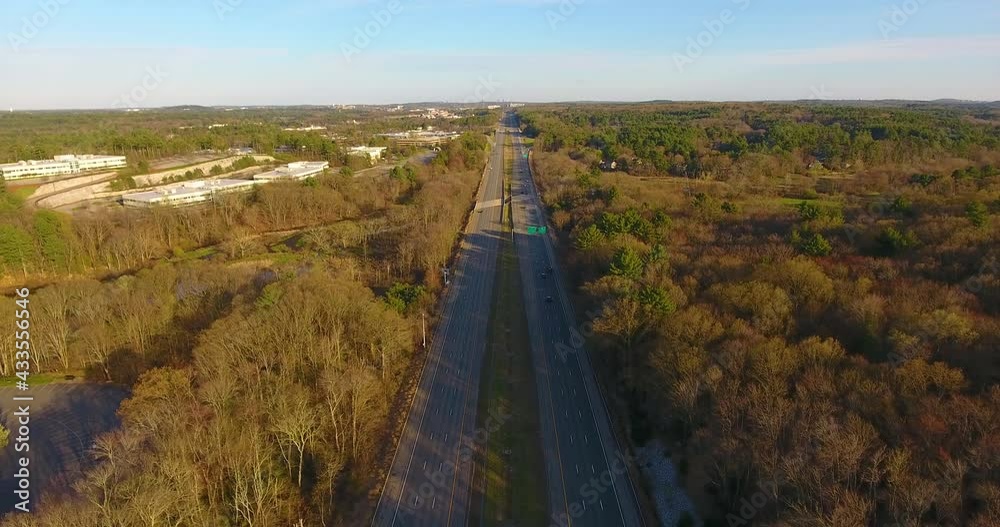 Flying over US route 3 highway northbound in spring with sunset twilight between Exit 73 and Exit 76 in town of Bedford, Massachusetts MA, USA. Flying over US route 3 highway northbound in spring with sunset twilight between Exit 73 and Exit 76 in town of Bedford, Massachusetts MA, USA.
