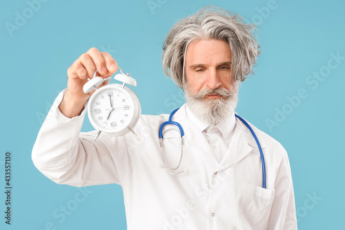 Tired doctor with alarm clo...