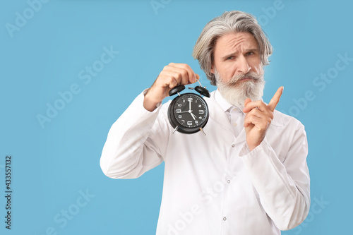 Doctor with alarm clock poi...