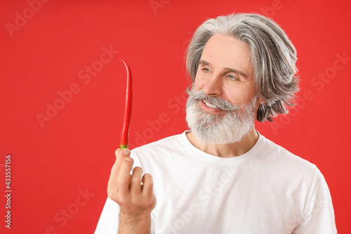 Senior man with chili peppe...