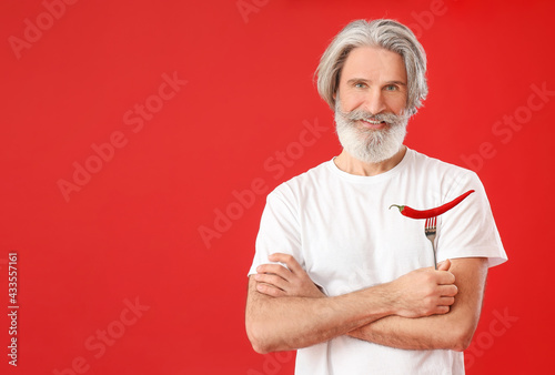 Senior man with chili peppe...