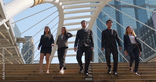 A group of business people of different ethnicities dressed in suits and ties walks proudly after leaving the offices. Concept of: team, success, connection and internationality.