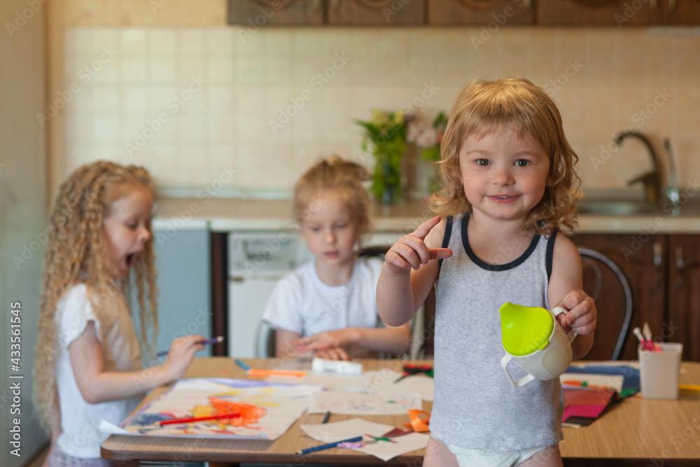 three children are engaged in creative work at the table at home: draw, cut the applique three children are engaged in creative work at the table at home: draw, cut the applique