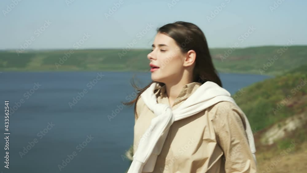 Portrait of young woman with brown hair spending leisure time on nature and hiking with backpack. Amazing view of Bakota bay on background. Portrait of young woman with brown hair spending leisure time on nature and hiking with backpack. Amazing view of Bakota bay on background.