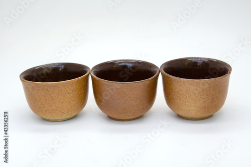 Brown tea cups on white background