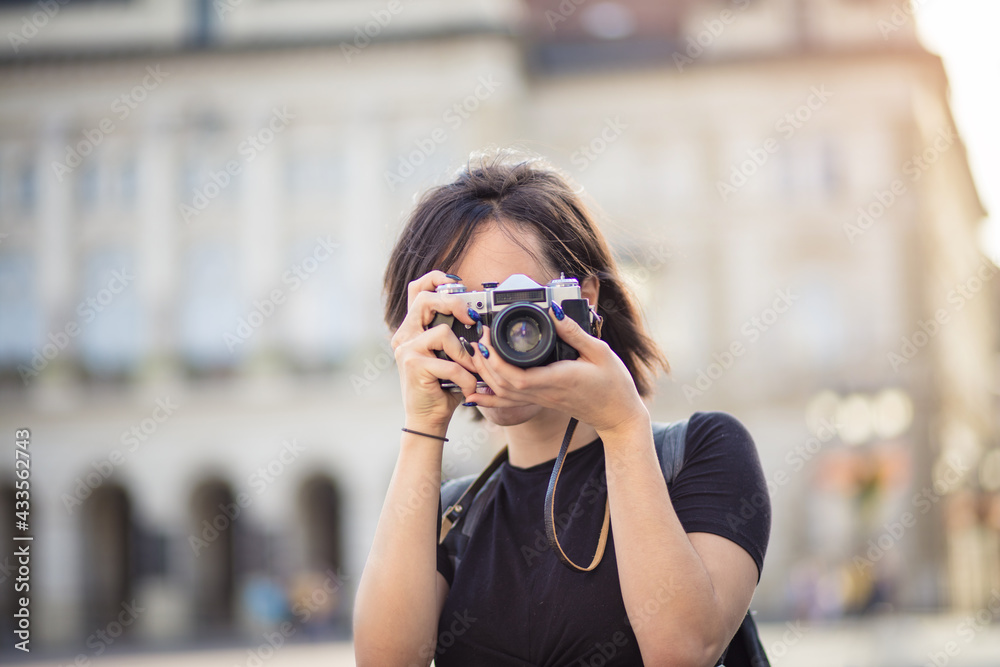  Young woman taking photo in the city with camera. I should definitely get a picture of that.