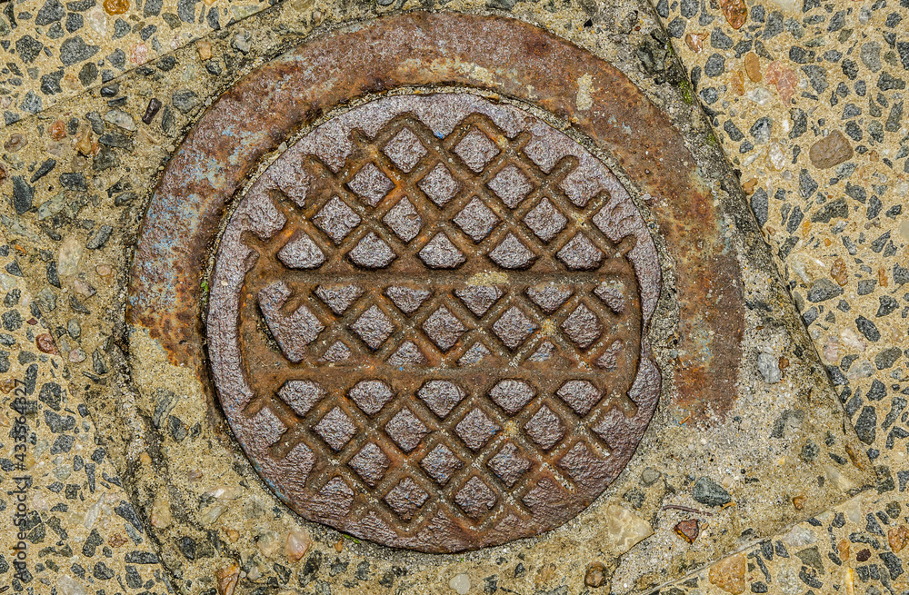 Rust has caused huge loses and damages to public and government properties / Rusty and Worn Cast Iron Manhole Covers Background / Closeup details of wear and bare metal surfaces
