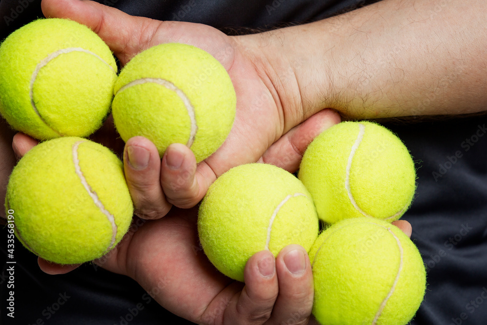 Tennis balls in men's hands. Back view. Close-up.