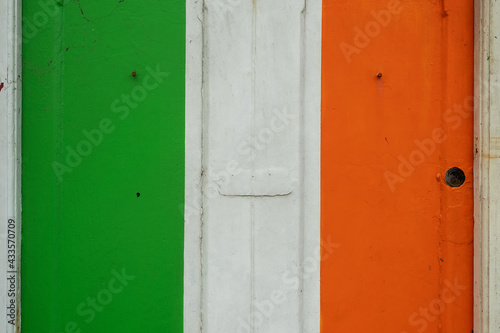 Old weathered door painted in colors of Irish National flag. Rich saturated colors. Expression of pride, love and patriotism to your country