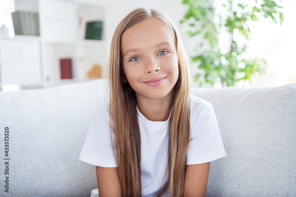 Portrait of young positive good mood beautiful charming little girl sit sofa having great weekend at home house