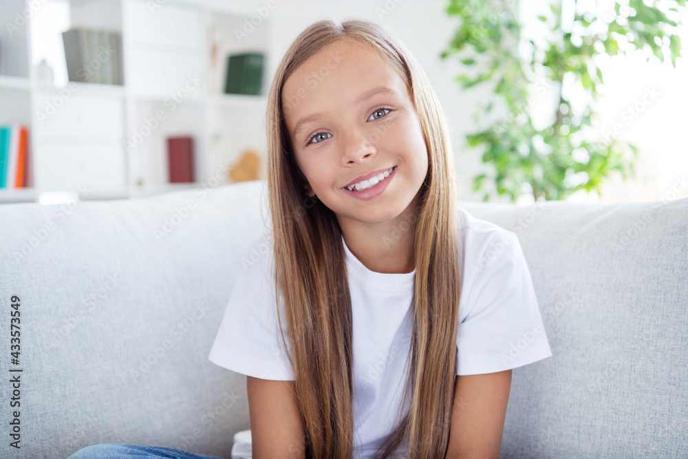 Photo of happy good mood pretty charming beautiful little girl with long blonde hair sit couch relaxing at home house Photo of happy good mood pretty charming beautiful little girl with long blonde hair sit couch relaxing at home house