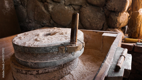 An ancient hand mill made of stones and wood. Flour grinding device. Authentic handicraft photo