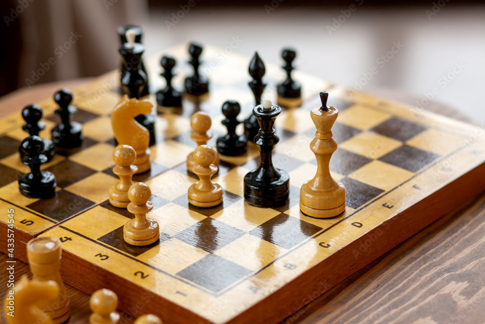 Wooden chess pieces on a board game, on vintage table, selective focus Wooden chess pieces on a board game, on vintage table, selective focus