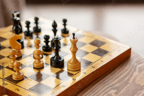 Wooden chess pieces on a board game, on vintage table, selective focus
