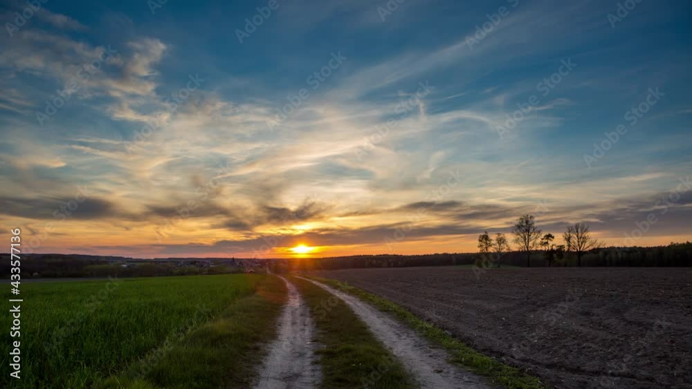 4k timelapse with beautiful, dramatic sunset sky over spring field and road 4k timelapse with beautiful, dramatic sunset sky over spring field and road