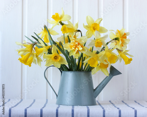 bouquet of yellow daffodils in a watering can.