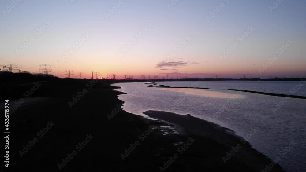 Sundown At The Riverside Of Brielse Meer With Electric Towers On The Background. aerial Sundown At The Riverside Of Brielse Meer With Electric Towers On The Background. aerial