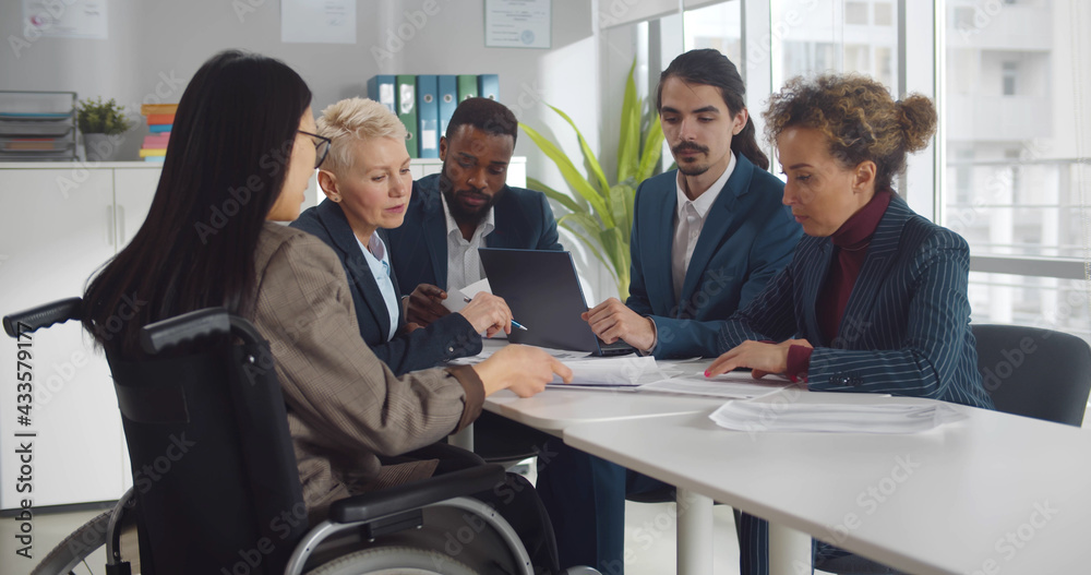 Disabled businesswoman with documents in conference room during meeting in modern office Disabled businesswoman with documents in conference room during meeting in modern office