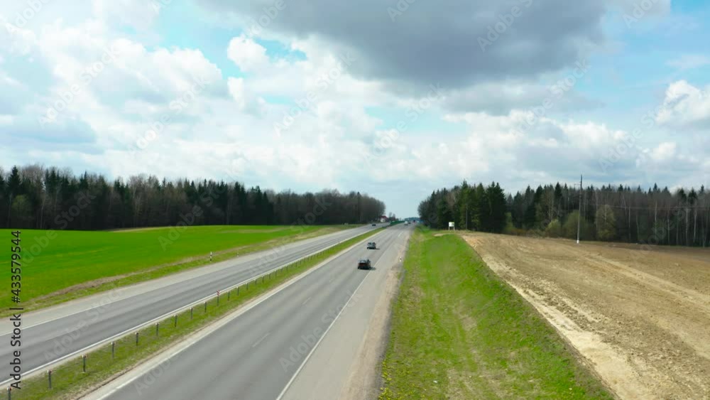Cars driving on freeway road in the spring field Cars driving on freeway road in the spring field