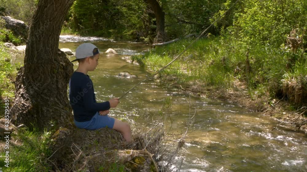 Boy fishing in a river on a summer day Boy fishing in a river on a summer day