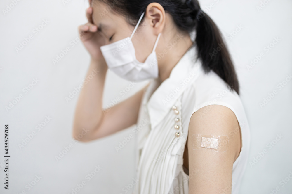 Tired asian child girl with a fever,headache,fatigue,dizziness,allergic reactions to the COVID-19 vaccine after injection,side effects of receiving medicine to prevent Coronavirus,vaccination concept Tired asian child girl with a fever,headache,fatigue,dizziness,allergic reactions to the COVID-19 vaccine after injection,side effects of receiving medicine to prevent Coronavirus,vaccination concept