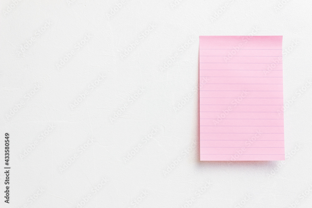 A pink paper on white wall. A pink paper on white wall.