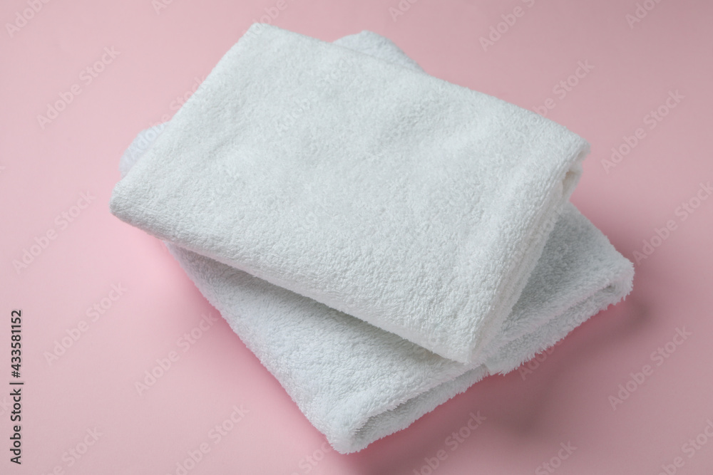 Clean folded towels on pink background, close up Clean folded towels on pink background, close up