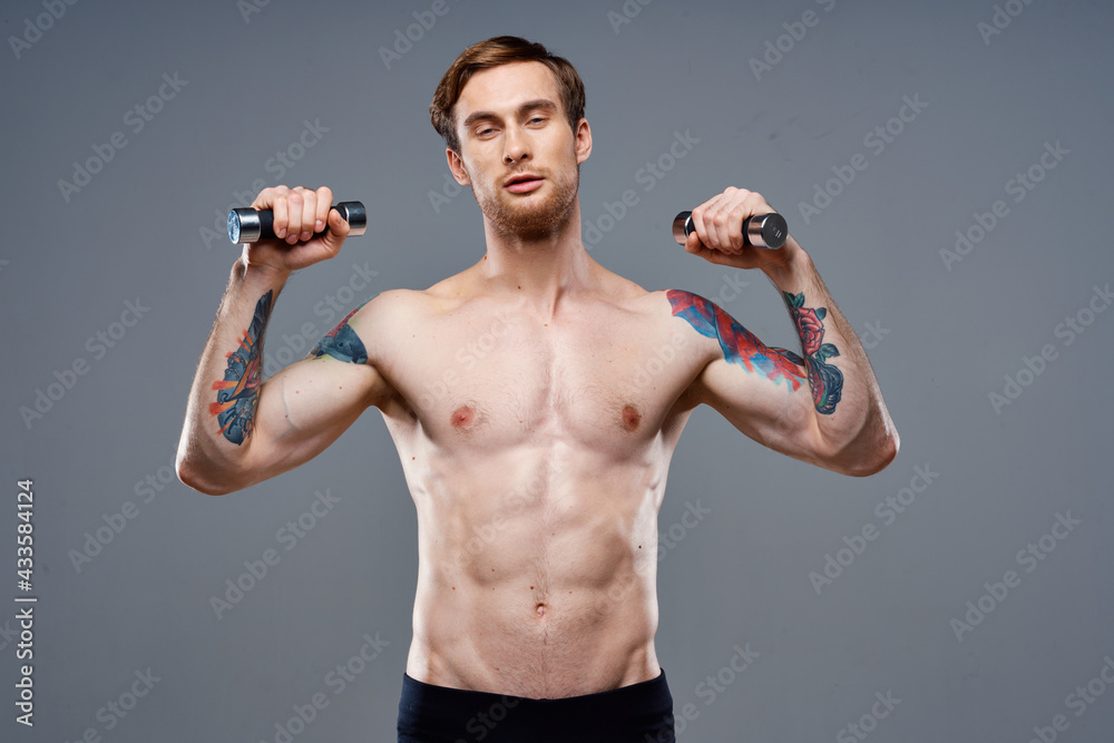 tattooed guy naked torso muscled dumbbells fitness sport