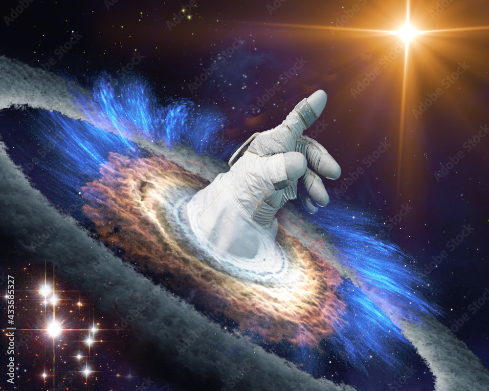 Astronaut hand in gloves points with finger to a shining star in space  through a black hole portal. Exploration concept. Elements of this image  furnished by NASA. Stock Photo | Adobe Stock