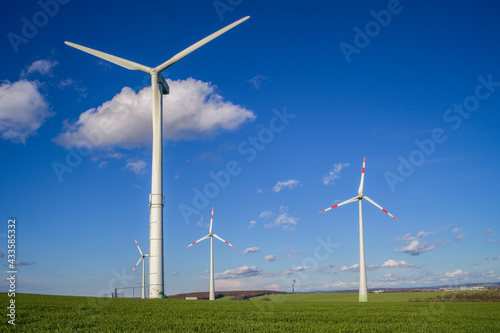 Wallpaper Mural Luftbildaufnahme von Windkrafträdern auf einer grünen Wiese mit blauem Himmel und Wolken im Hintergrund Torontodigital.ca