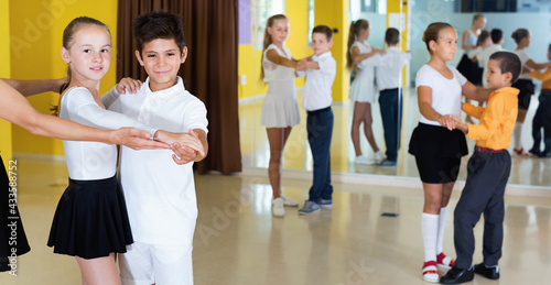 Group of diligent children dancing tango in dance studio