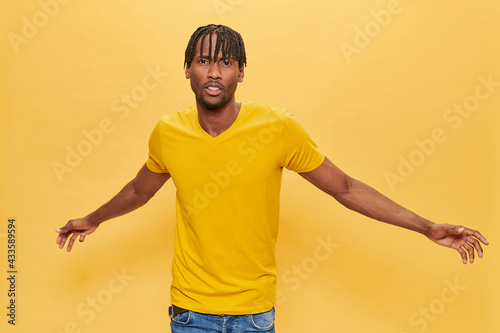 Handsome Afro Man Posing Over Yellow Background wearing yellow t-shirt