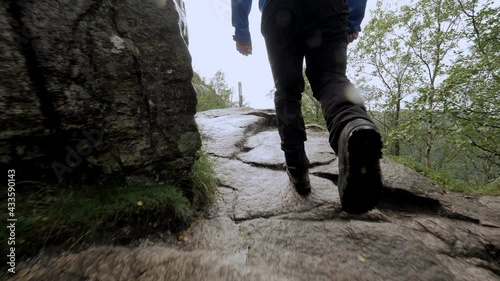 Closeup man legs hiking on natural stones climbing on mountain at tropical rainforest